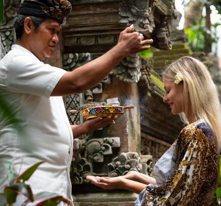 Woman participating in a traditional Balinese healing ceremony at a retreat