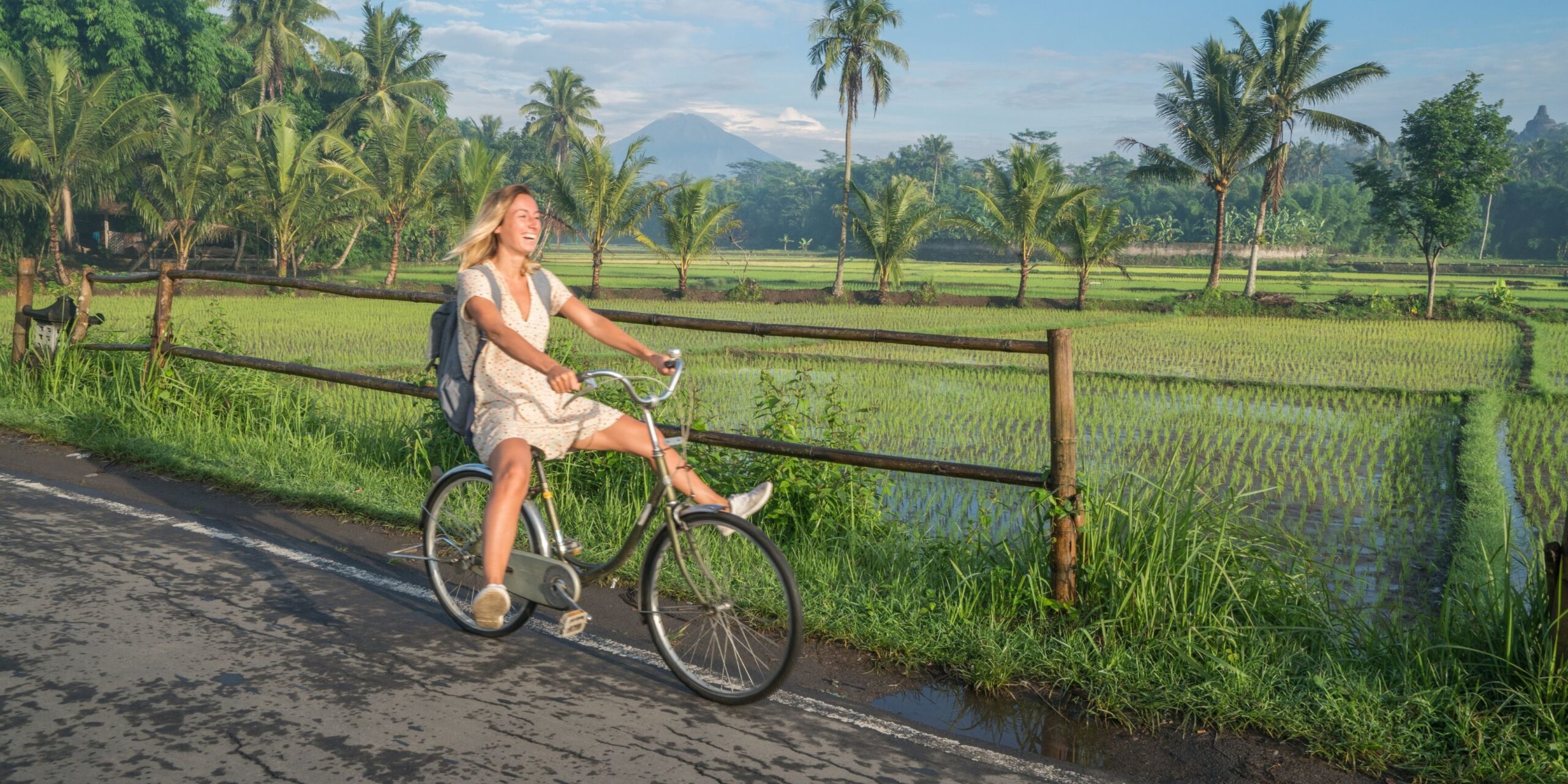 Women riding through rice paddies on eat pray love style luxury wellness retreat in Bali